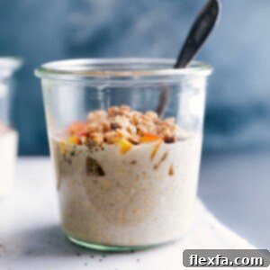 Peach overnight oats in a bowl, ready to be eaten, topped with fresh peach slices and crunchy granola.
