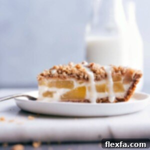 A slice of Apple Streusel Pie with a creamy filling, crunchy streusel, and a sweet drizzle.