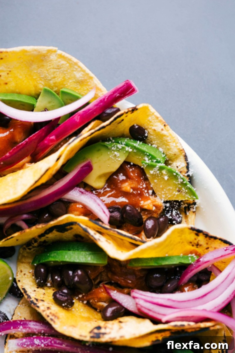 Platter of Chipotle Chicken Tacos with Vegetable and Bean Toppings Chipotle chicken tacos on a platter, topped with fresh vegetables and beans.