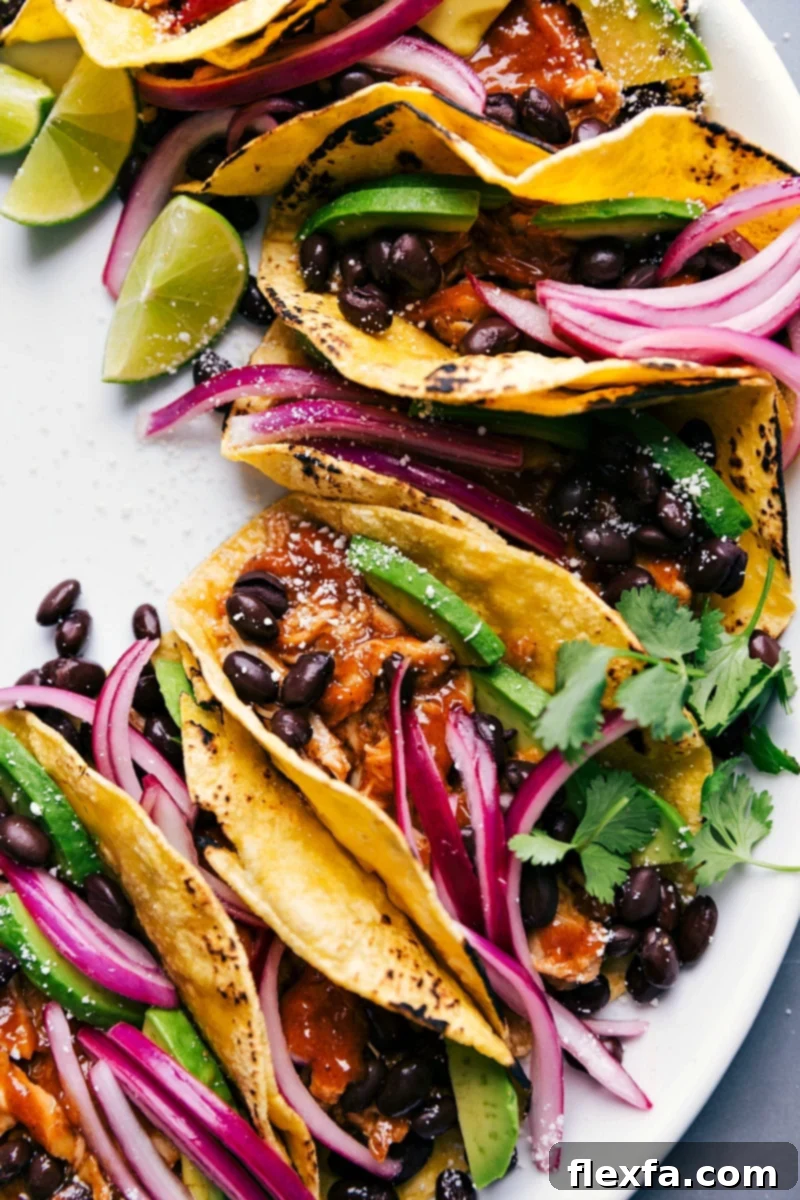 Ready-to-Eat Chipotle Chicken Tacos with Cilantro, Pickled Onions, and More Finished chipotle chicken tacos, ready to eat, topped with fresh cilantro, pickled onions, and other toppings.