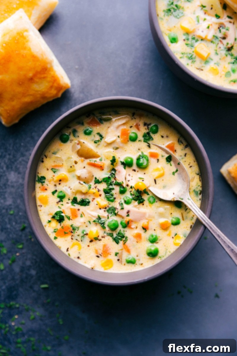 Hearty Chicken Pot Pie Soup - A Comforting Bowl of Warmth A steaming bowl of Chicken Pot Pie Soup, rich with chicken and vegetables, garnished with fresh herbs, ready to be enjoyed.