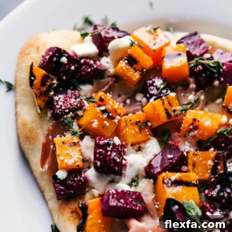 Close-up overhead image of a sliced section of the beet and goat cheese flatbread, showcasing the crispy crust, vibrant toppings, and melted goat cheese