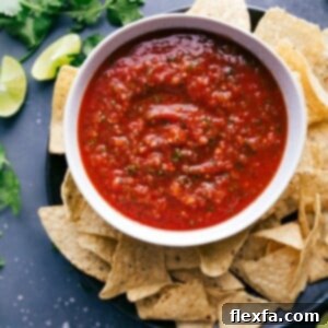 A big bowl of delicious salsa, packed with vibrant flavors, paired with a pile of crispy chips ready for dipping.