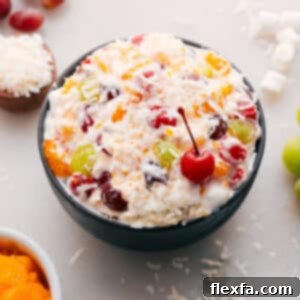 The finished Ambrosia Salad, rich and creamy with colorful fruit and marshmallows, ready to be served from a large bowl.