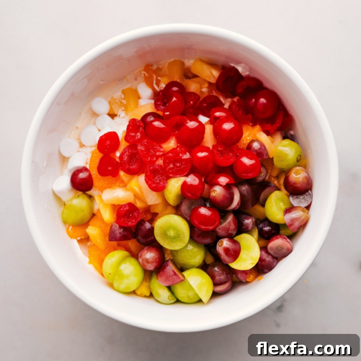 A large bowl filled with a colorful mix of fruit and marshmallow ingredients, perfectly prepped and ready for the creamy dressing.