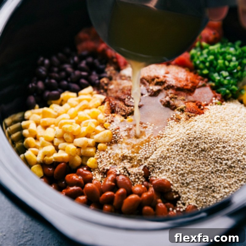Pouring vegetable stock into the Crockpot Quinoa mixture.