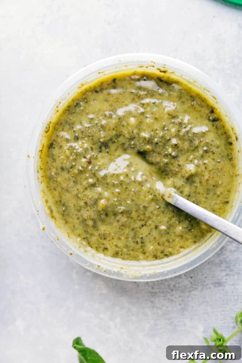 Process shot showing a small bowl of vibrant green basil pesto, ready to be incorporated into the Pesto Chicken Tortellini.