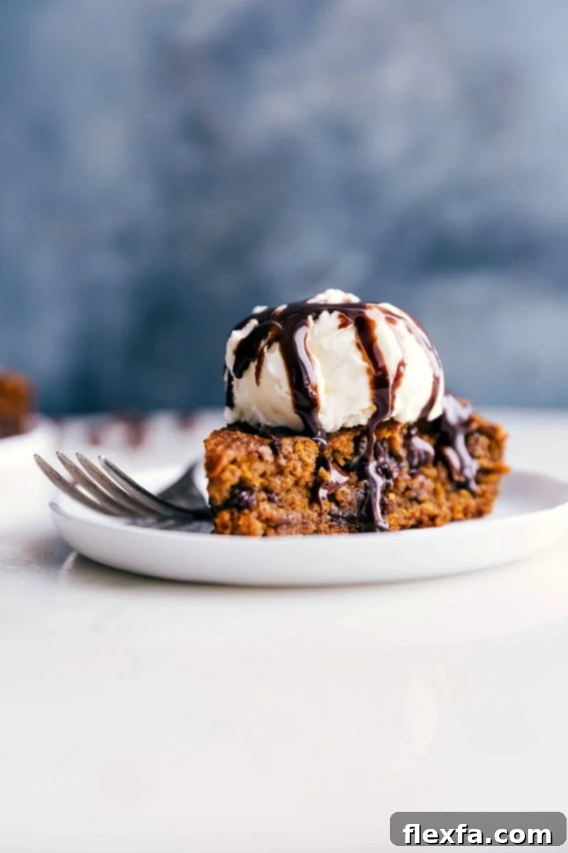 Delectable Gluten-Free Pumpkin Cake with Ice Cream, Ready to Savor A slice of moist gluten-free pumpkin cake on a white plate, beautifully topped with a scoop of vanilla ice cream, ready to be enjoyed.