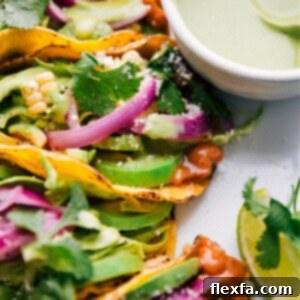 Pinto Bean Tacos served on a plate with fresh lime wedges and cilantro.