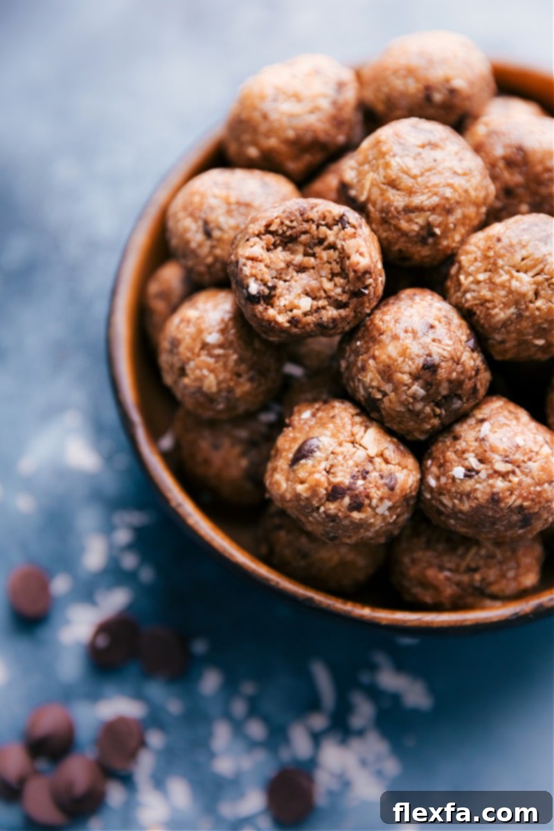 A close-up shot of a bowl of Oatmeal Energy Bites, with one ball thoughtfully bitten into, revealing its delicious and textured interior.
