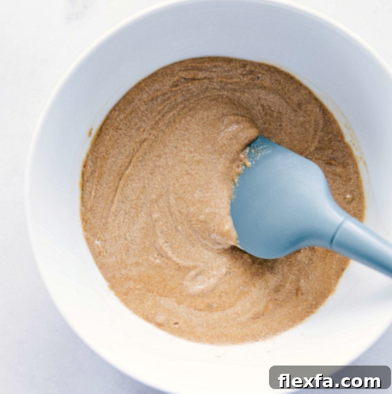 The perfectly mixed wet ingredients for Gluten-Free Monster Cookies: peanut butter, coconut oil, sugar, and eggs, ready for dry ingredients.