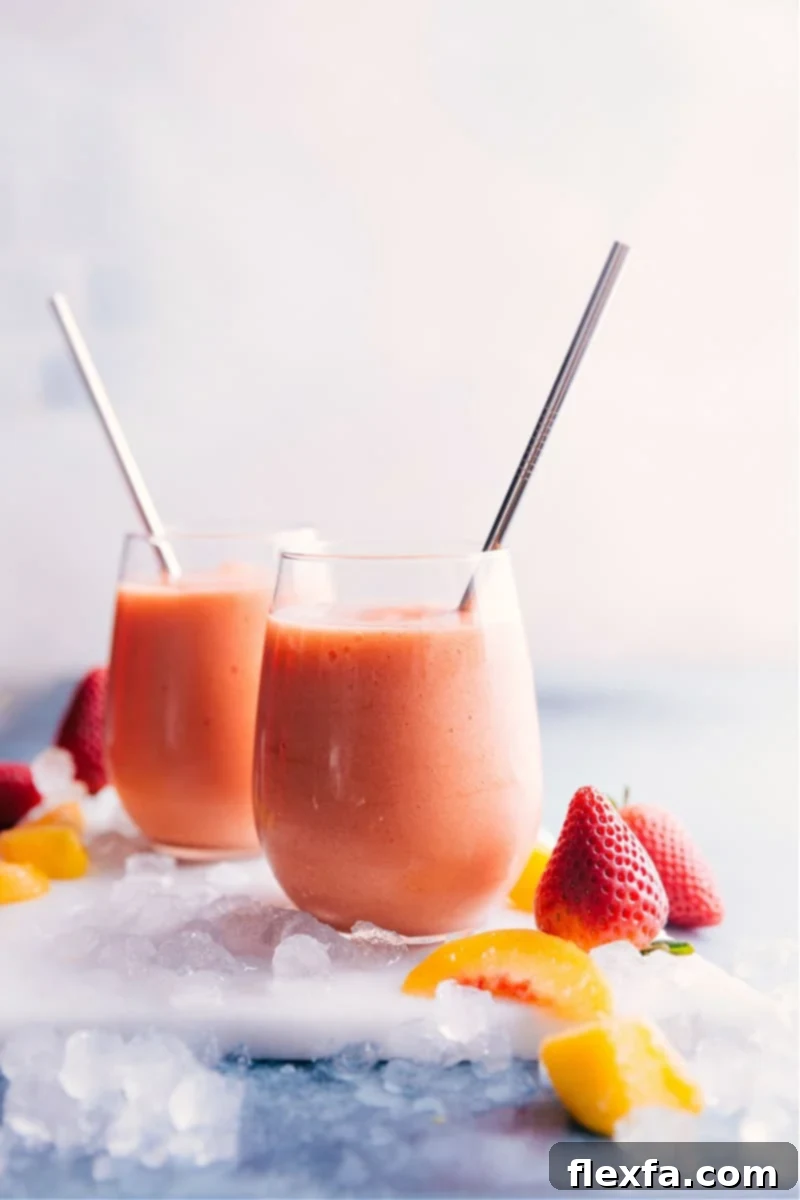 Homemade Caribbean Passion Smoothie - Your Favorite Jamba Juice Copycat Two glasses of vibrant Caribbean Passion Smoothies, garnished with fresh fruit, on a wooden surface.