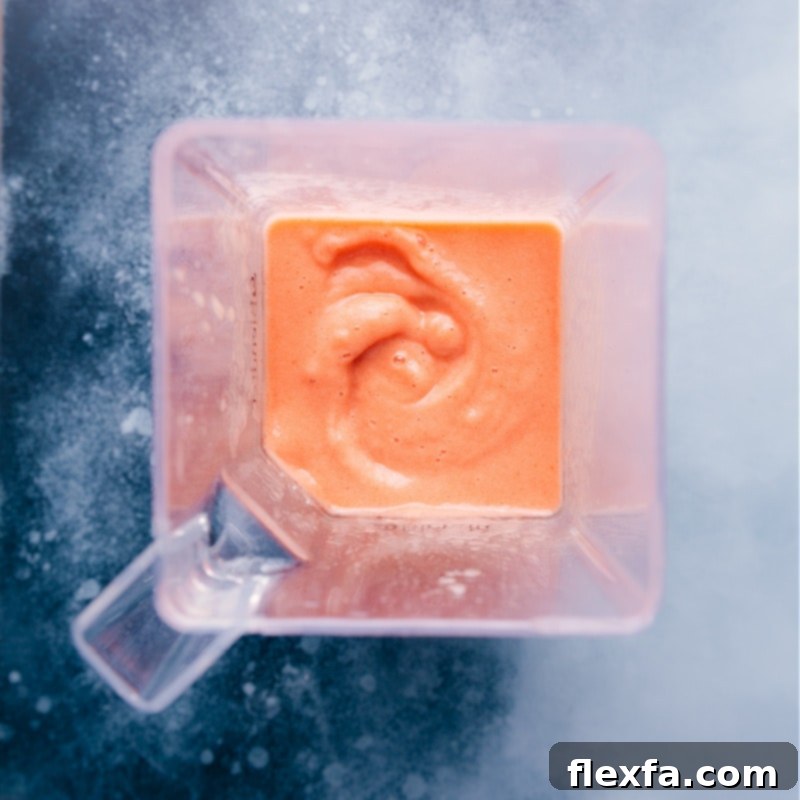 Smoothie Perfection: Ready to Enjoy Overhead view of a perfectly blended Caribbean Passion Smoothie in a blender, showing its thick and creamy texture.