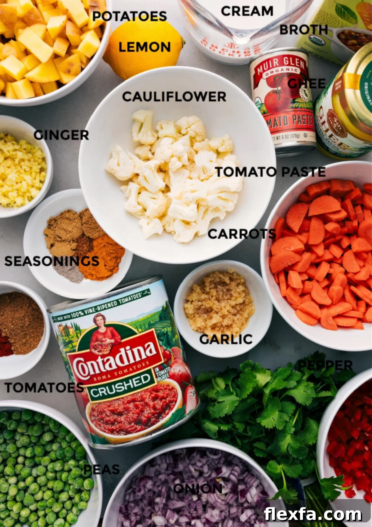 All the fresh ingredients neatly prepped and laid out for Vegetable Masala: colorful vegetables, aromatic spices, crushed tomatoes, ghee, tomato paste, vegetable broth, heavy cream, and a fresh lemon.