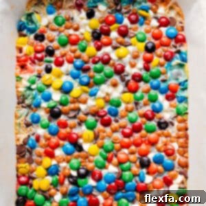 Close-up of a stack of Magic Cookie Bars, showing the rich texture and colorful toppings.