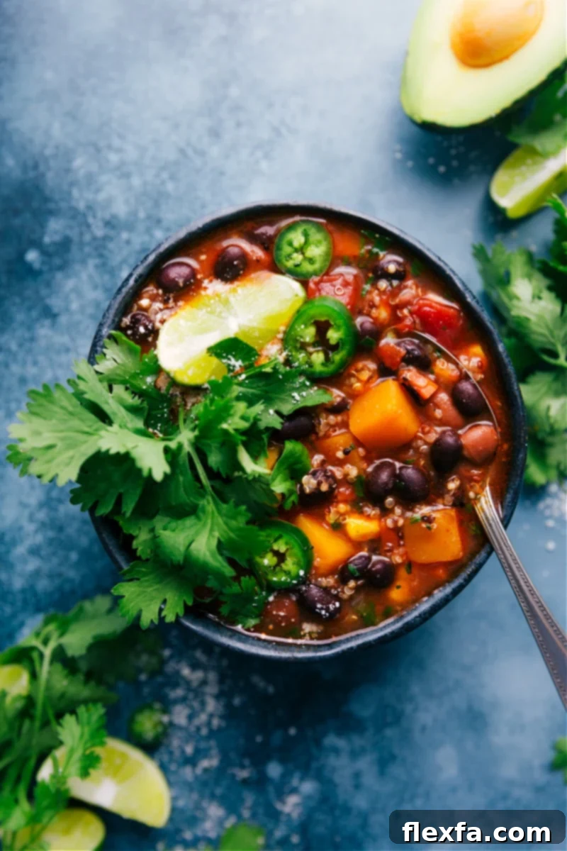 Overhead image of a generous bowl of Slow Cooker Butternut Squash Chili, beautifully garnished with fresh cilantro and a dollop of creamy sour cream.