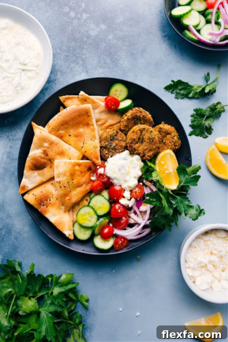 A plate filled with Air Fryer Falafels, pita triangles, and tzatziki sauce, ready to be enjoyed.