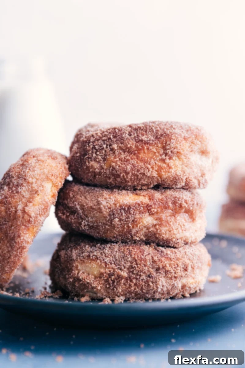 Up-close image of Air Fryer Donuts stacked on top of each other, showing the fluffy texture and cinnamon sugar coating.
