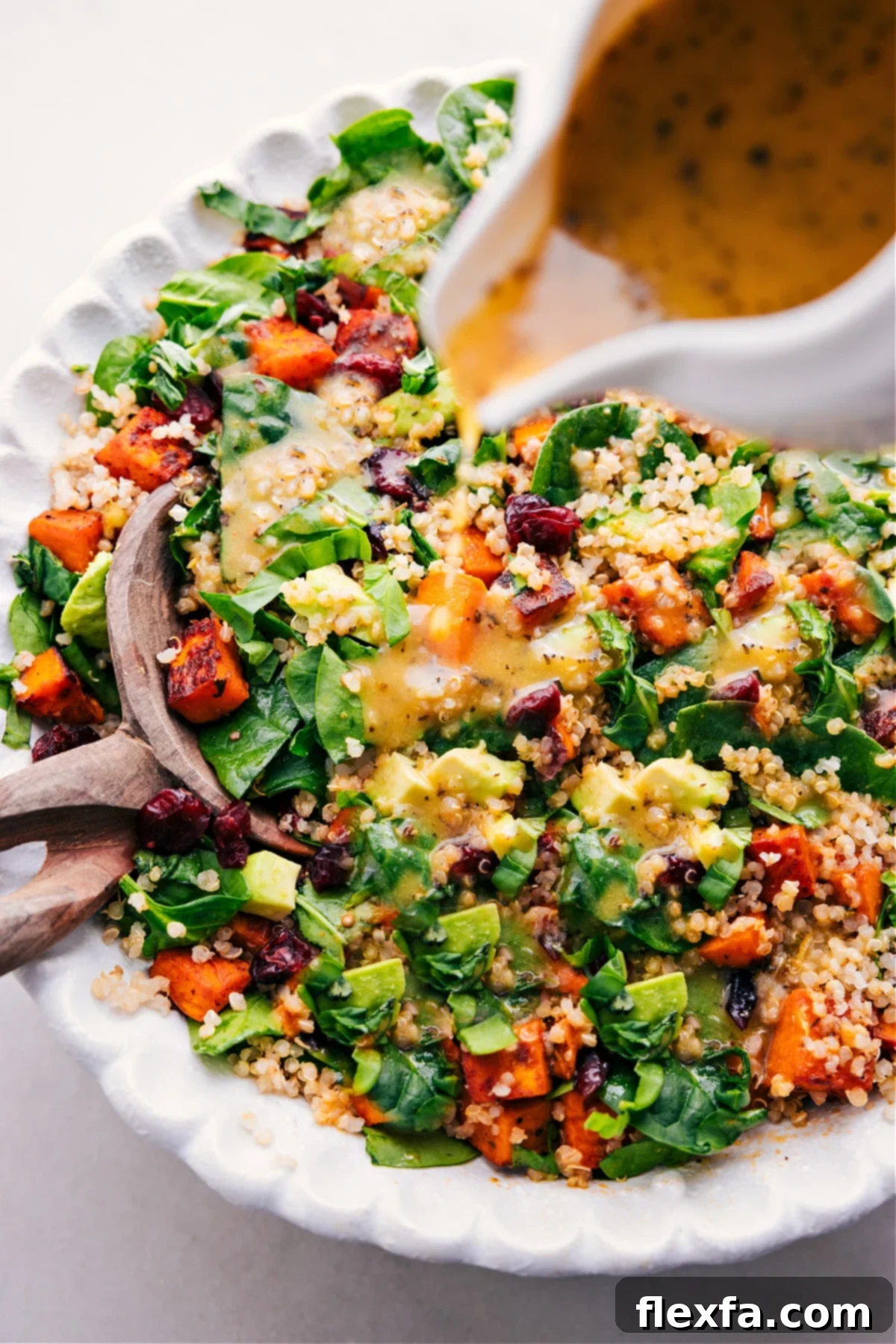 The vibrant lemon vinaigrette being generously poured over the Sweet Potato Quinoa Salad, making it perfectly dressed and ready to serve.