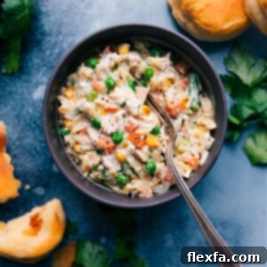 A close-up shot of the finished Chicken Pot Pie Pasta, showing the creamy orzo, tender chicken, and vegetables, garnished with fresh herbs.