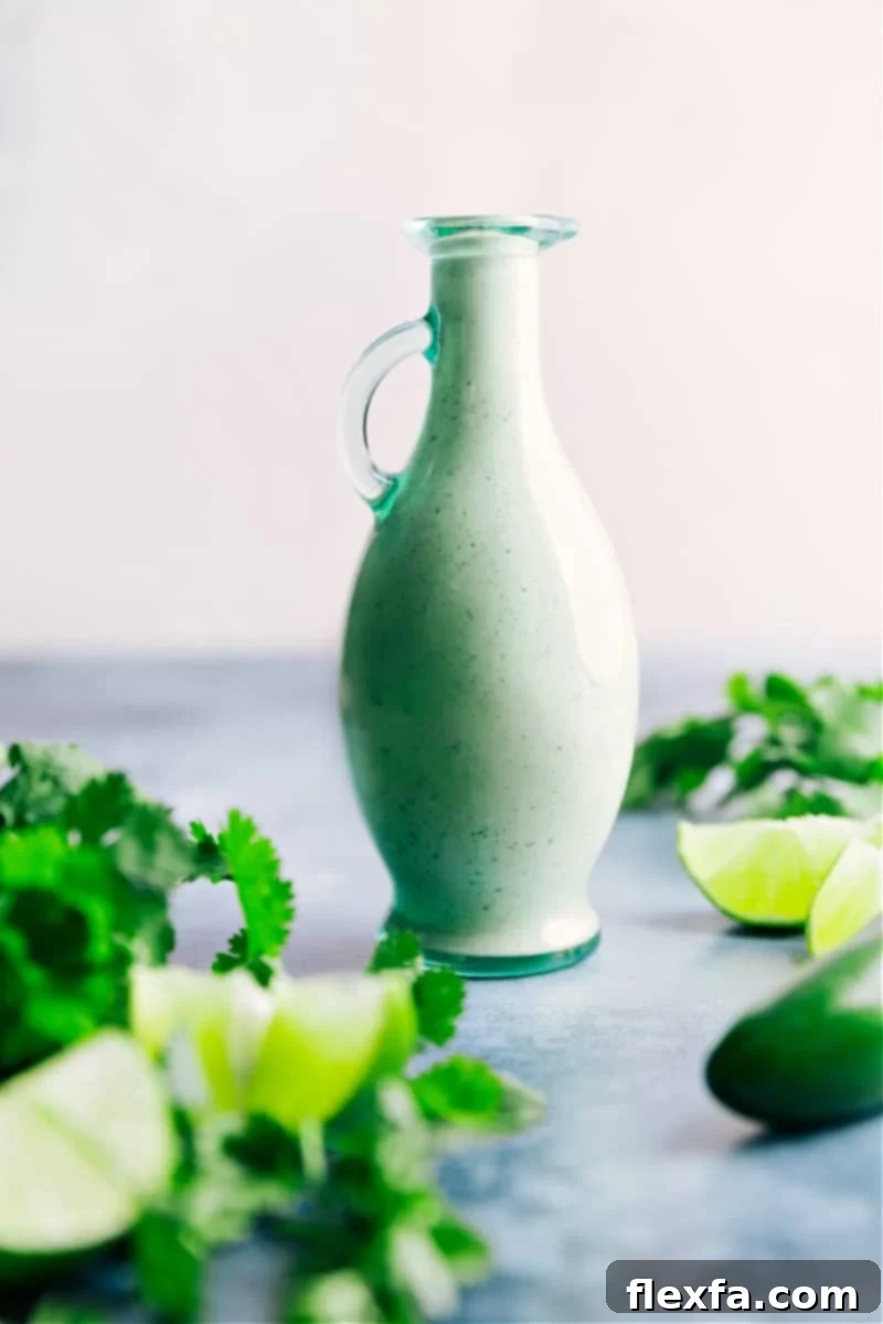 A beautifully presented jar of homemade Cafe Rio Dressing, showcasing its creamy texture and vibrant green specks of cilantro, ready to be drizzled over a fresh, colorful salad.