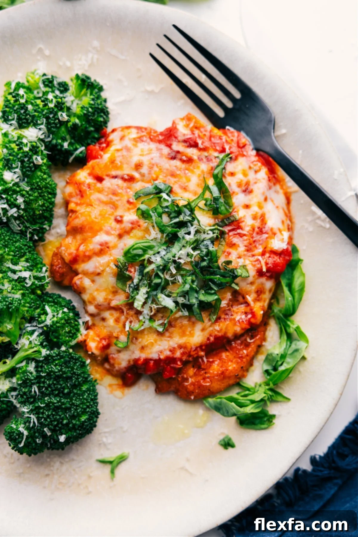 Pure Comfort Food: Parmesan Chicken Recipe Perfectly cooked Parmesan Chicken Recipe topped with fresh Parmesan and basil, ready to serve.