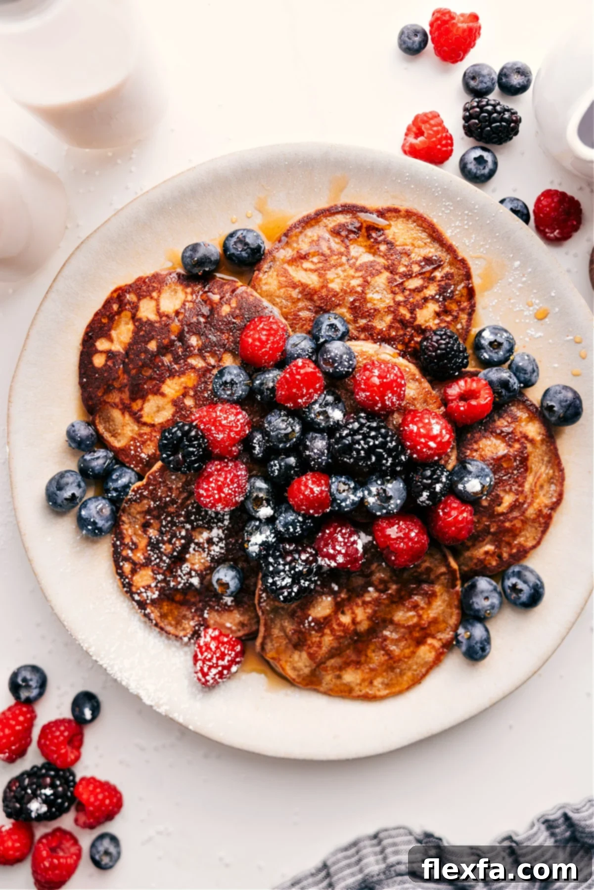 Wholesome Pancakes: A Guilt-Free Delight 2 Healthy Pancakes topped with berries, syrup, and powdered sugar