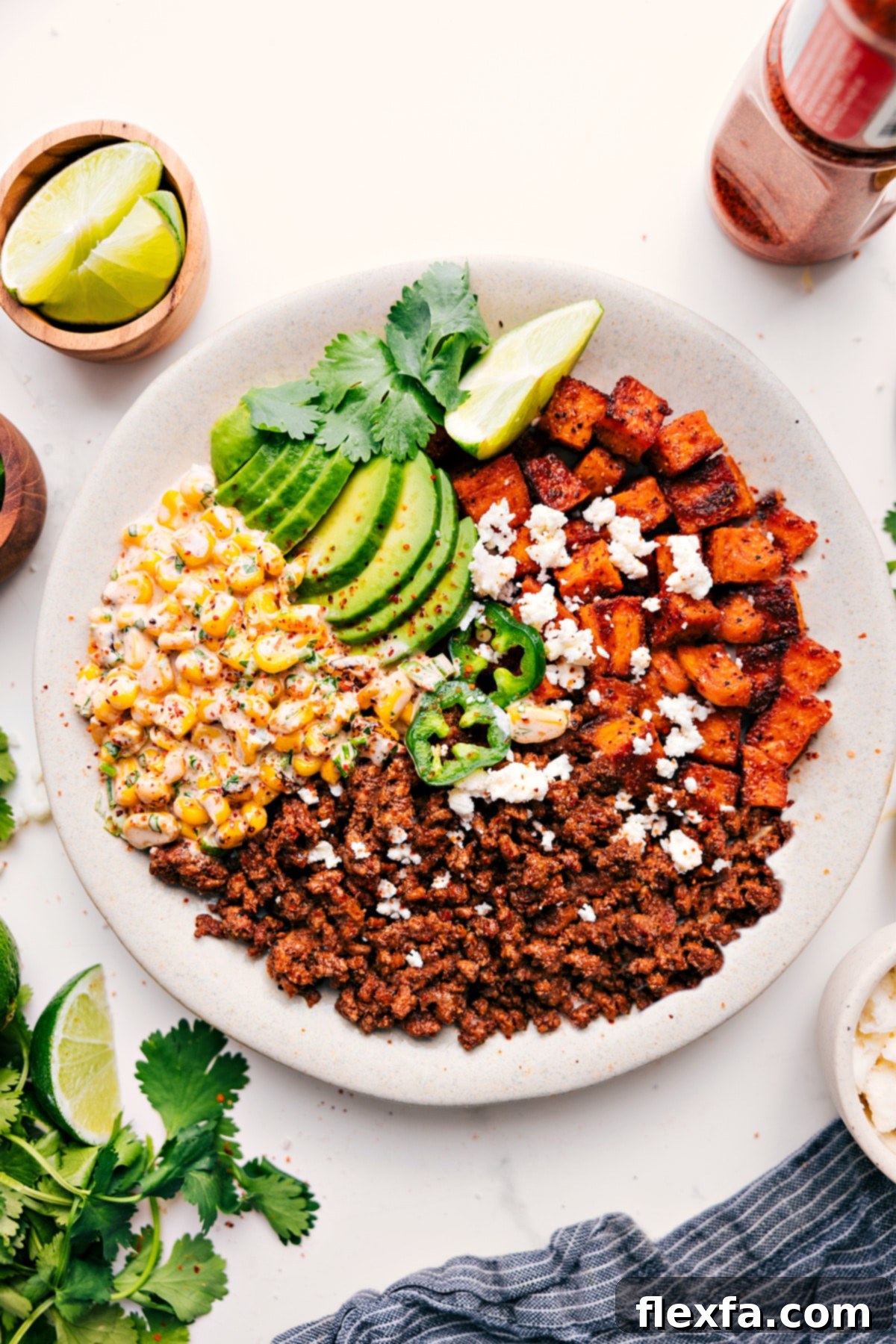 Street Corn Beef Bowl topped with crumbled cheese, Tajín seasoning, and sliced jalapeños.