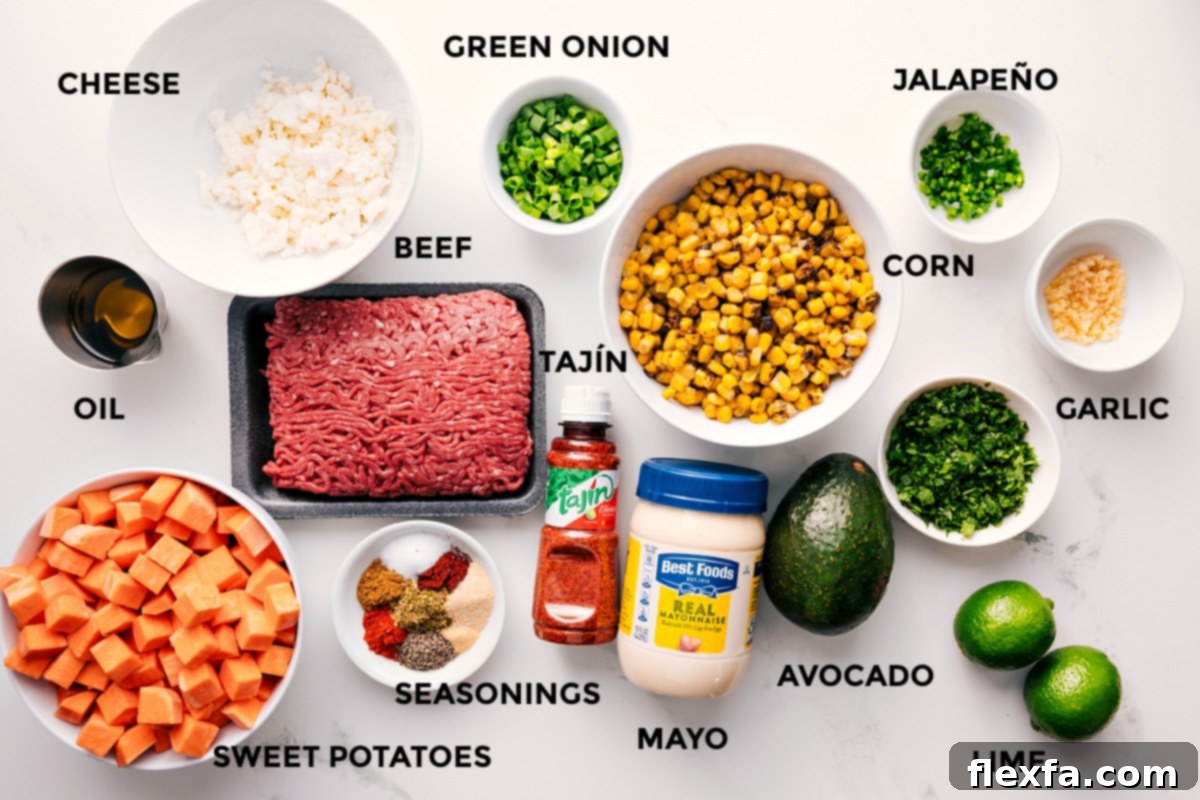All the ingredients in this recipe prepped out for easy assembly including the cheese, oil, sweet potatoes, beef, seasonings, tajin, mayo, avocado, lime, garlic, jalapeno, corn, and green onions.