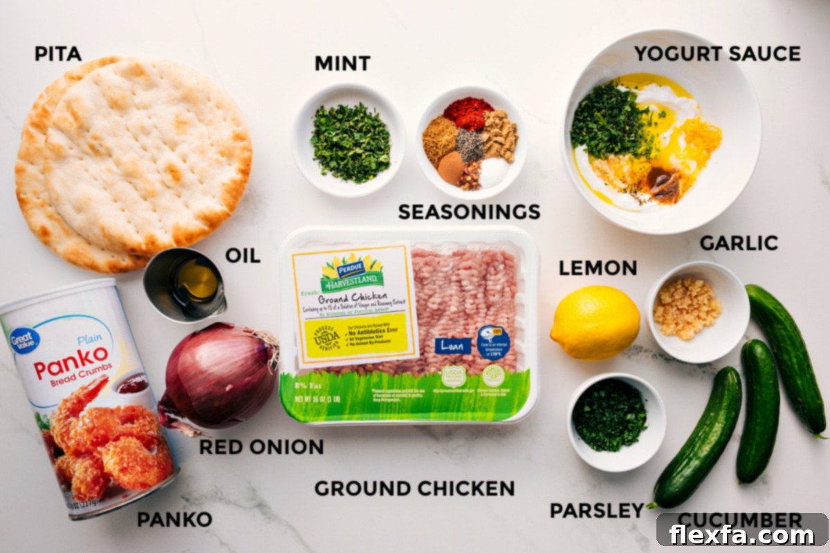 All the ingredients in this recipe prepped out for easy assembly including the pita, panko, oil, red onion, mint, seasonings, chicken, lemon, parsley, cucumber, and yogurt sauce.
