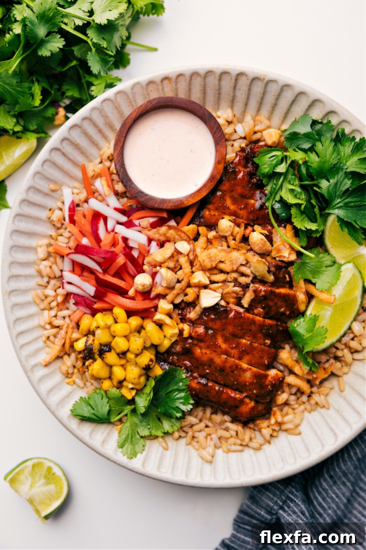 An Asian chicken bowl with rice and crisp vegetables.