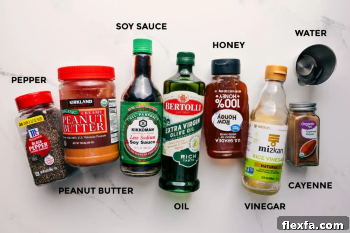 All the ingredients in this recipe prepped out for easy assembly including the pepper, peanut butter, soy sauce, oil, honey, vinegar, water, and cayenne.