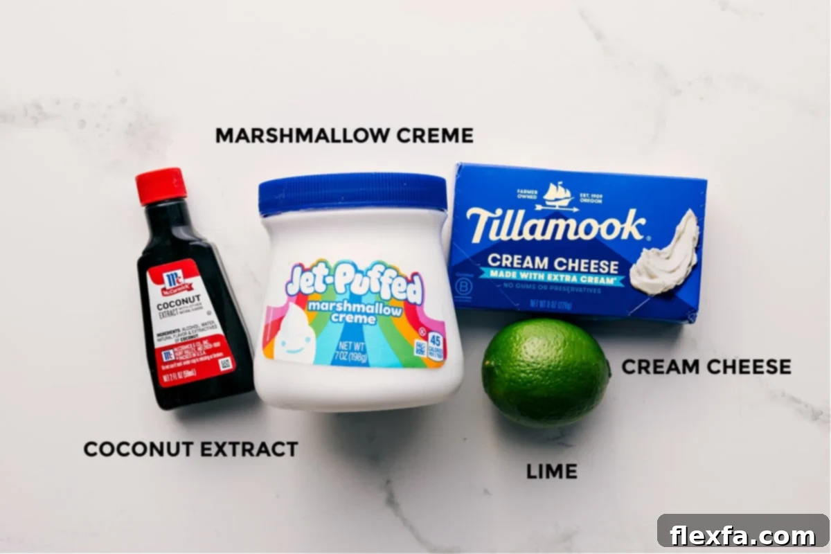 All the essential ingredients for this cream cheese fruit dip recipe, prepped for easy mixing, including full-fat cream cheese, marshmallow creme, fresh lime, and a small bottle of coconut extract.