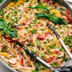 A bowl of freshly prepared Chicken Primavera with a garnish of basil.