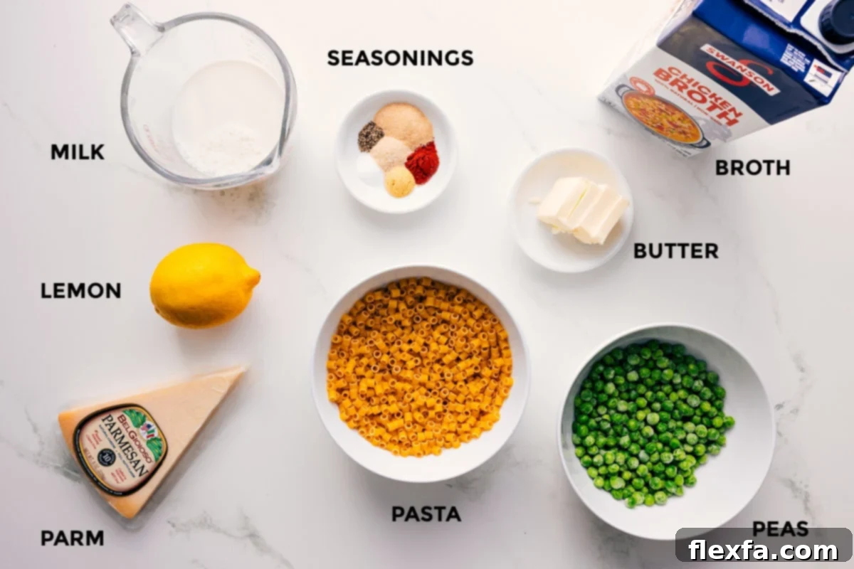 All the ingredients for pasta with peas recipe prepped out for easy assembly including milk, lemon, Parmesan, seasonings, pasta, peas, butter, and broth.
