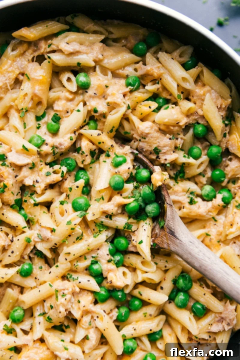 A comforting skillet of cheesy Tuna Pasta with green peas.