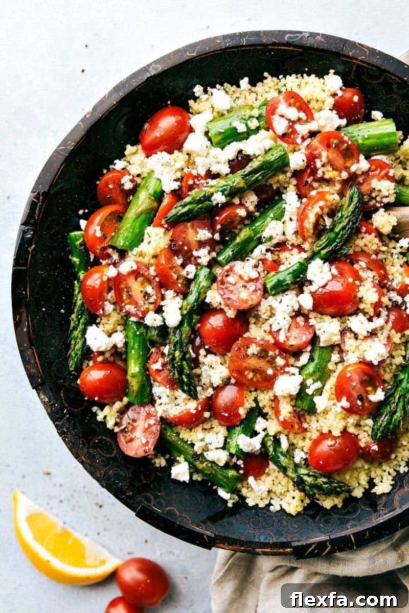 Vibrant Asparagus Salad with roasted vegetables, couscous, and feta cheese.