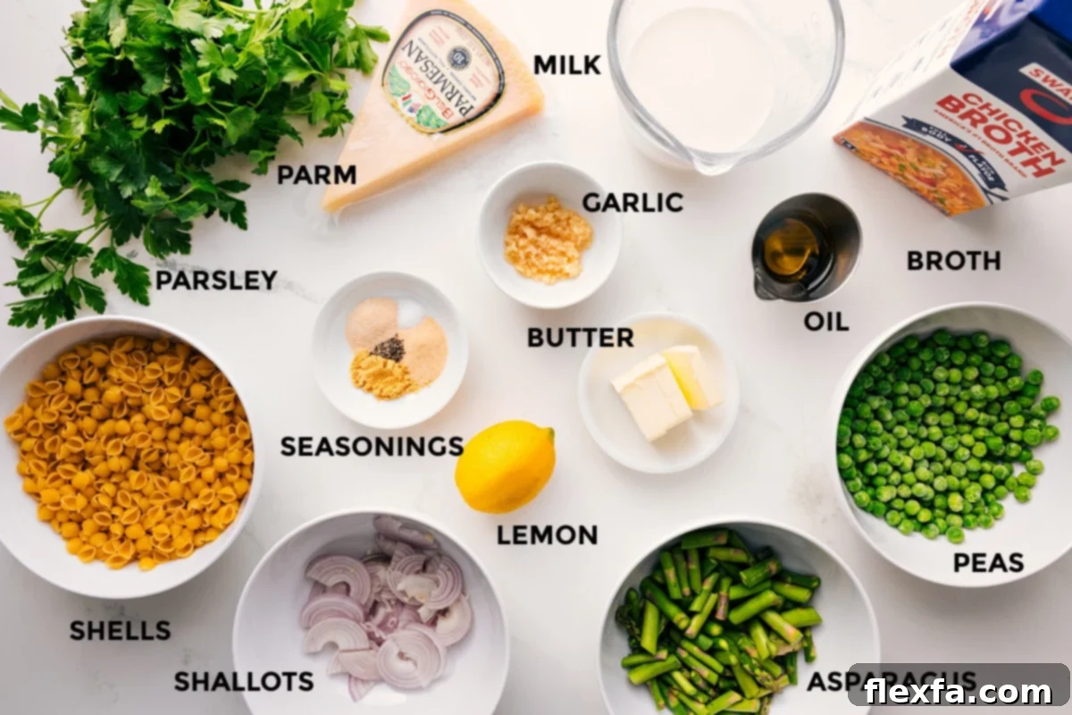 All the ingredients in this recipe prepped out for easy assembly including the parsley, shells, shallots, asparagus, peas, lemon, seasonings, butter, garlic, oil, broth, milk, and parmesan. 