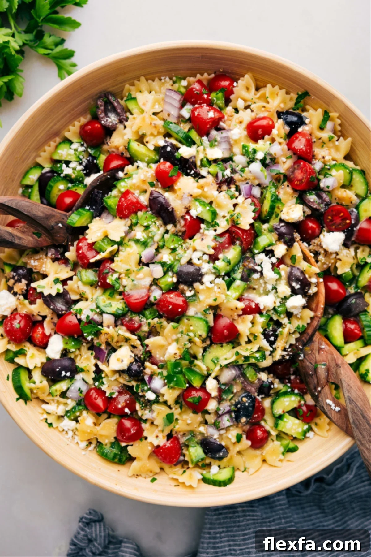 A vibrant bowl of Easy Greek Pasta Salad, filled with tender pasta, fresh vegetables like cucumbers and tomatoes, feta cheese, and a light dressing.
