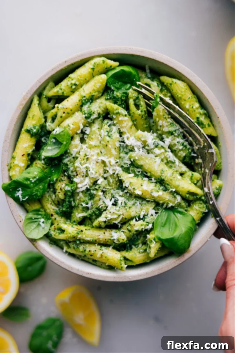 A vibrant bowl of Pesto Pasta, ready in under 20 minutes, featuring fresh basil pesto, Parmesan, and cherry tomatoes.