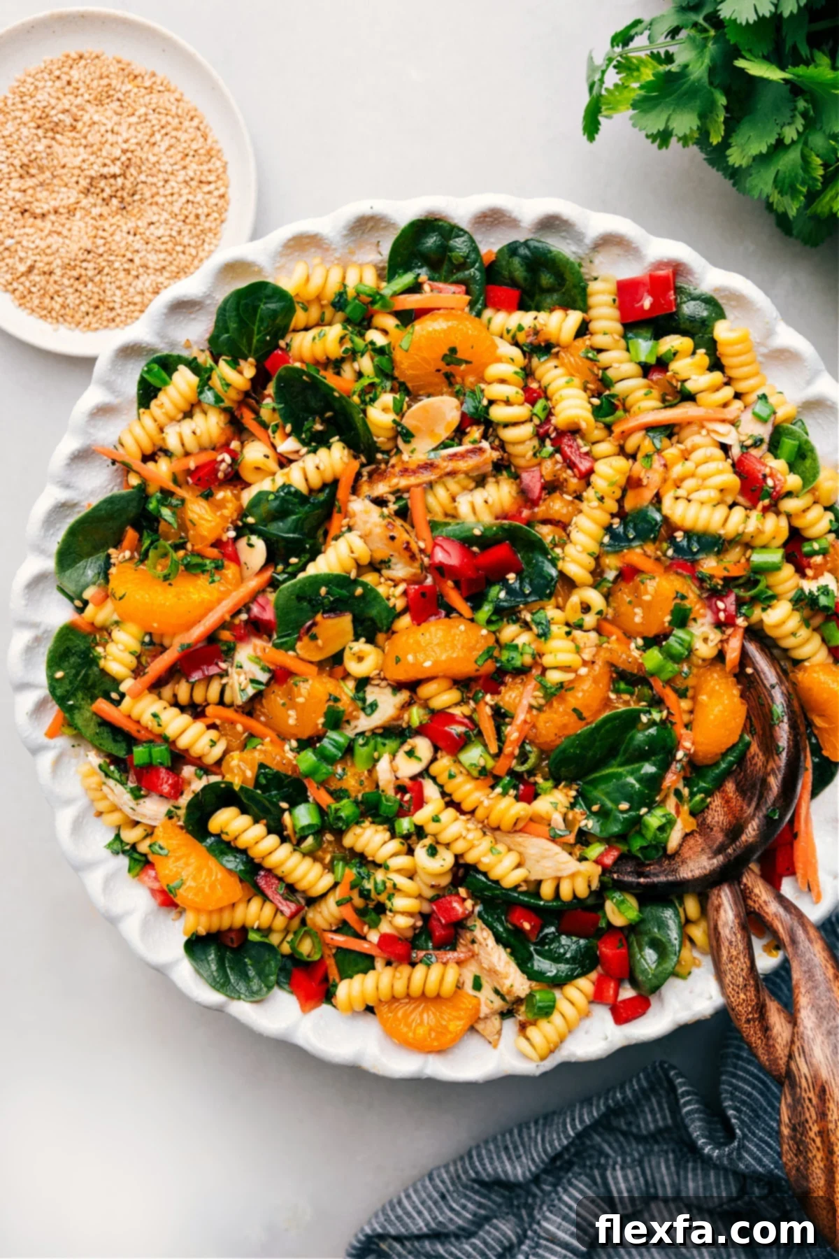 A vibrant Asian Pasta Salad with crisp vegetables, noodles, and a rich sesame-soy dressing, garnished with fresh herbs.