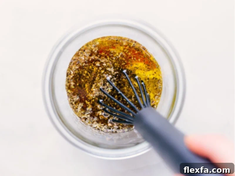 Process shots depicting the Italian dressing being vigorously whisked together in a glass jar, demonstrating the ease of achieving a smooth, emulsified texture.