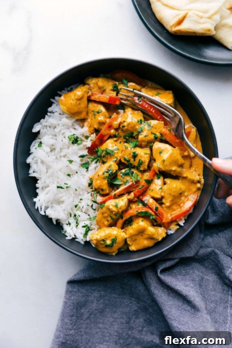 Creamy and flavorful coconut curry chicken, served with fluffy rice and warm naan bread, ready to be enjoyed.