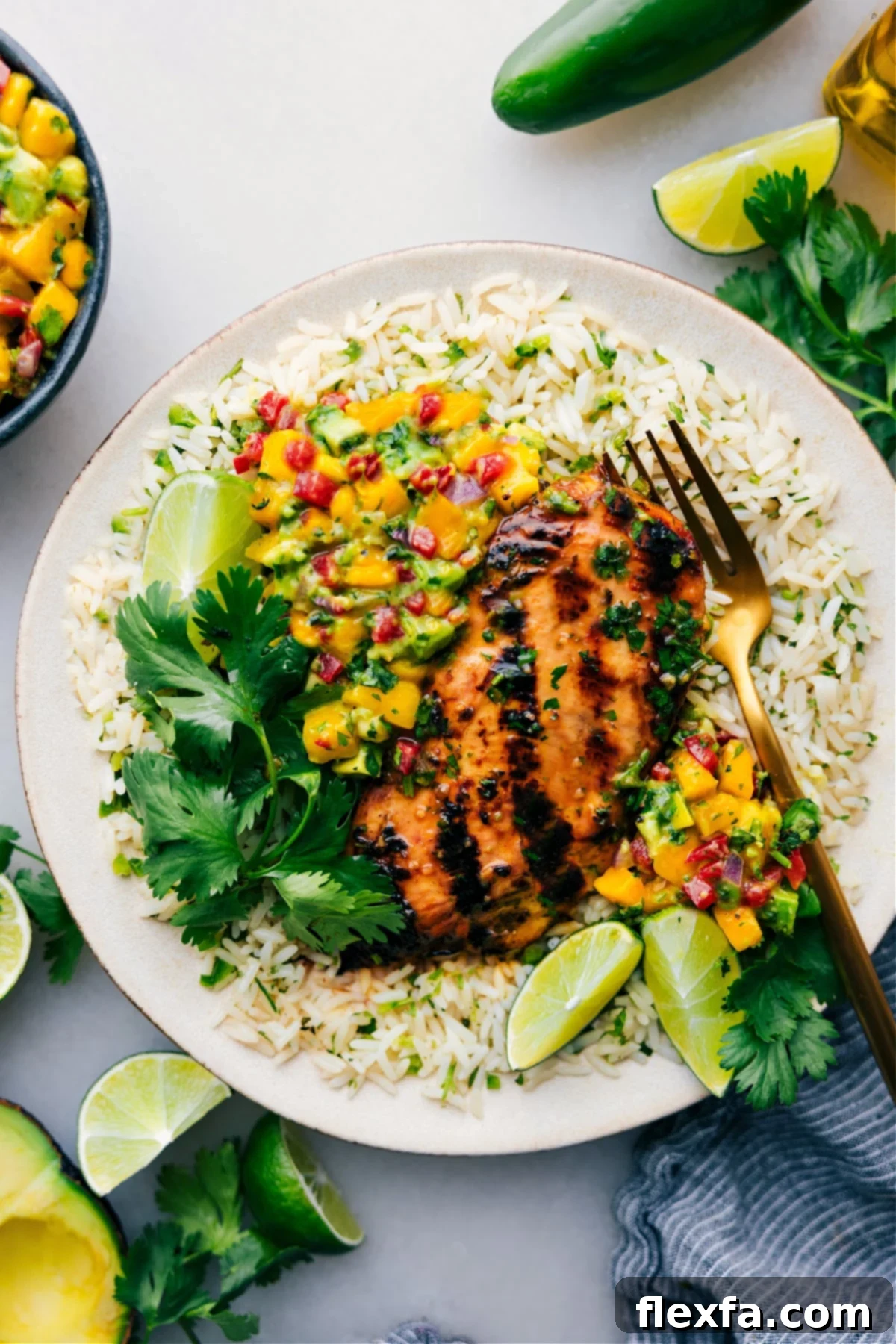 Vibrant cilantro lime chicken served over a bed of rice with fresh mango avocado salsa.
