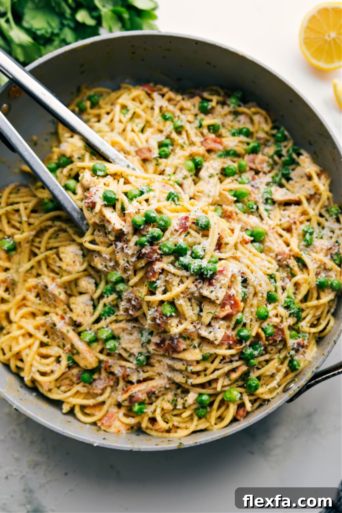A creamy and delicious pot of chicken carbonara, featuring crispy bacon and tender chicken in a no-cream sauce.