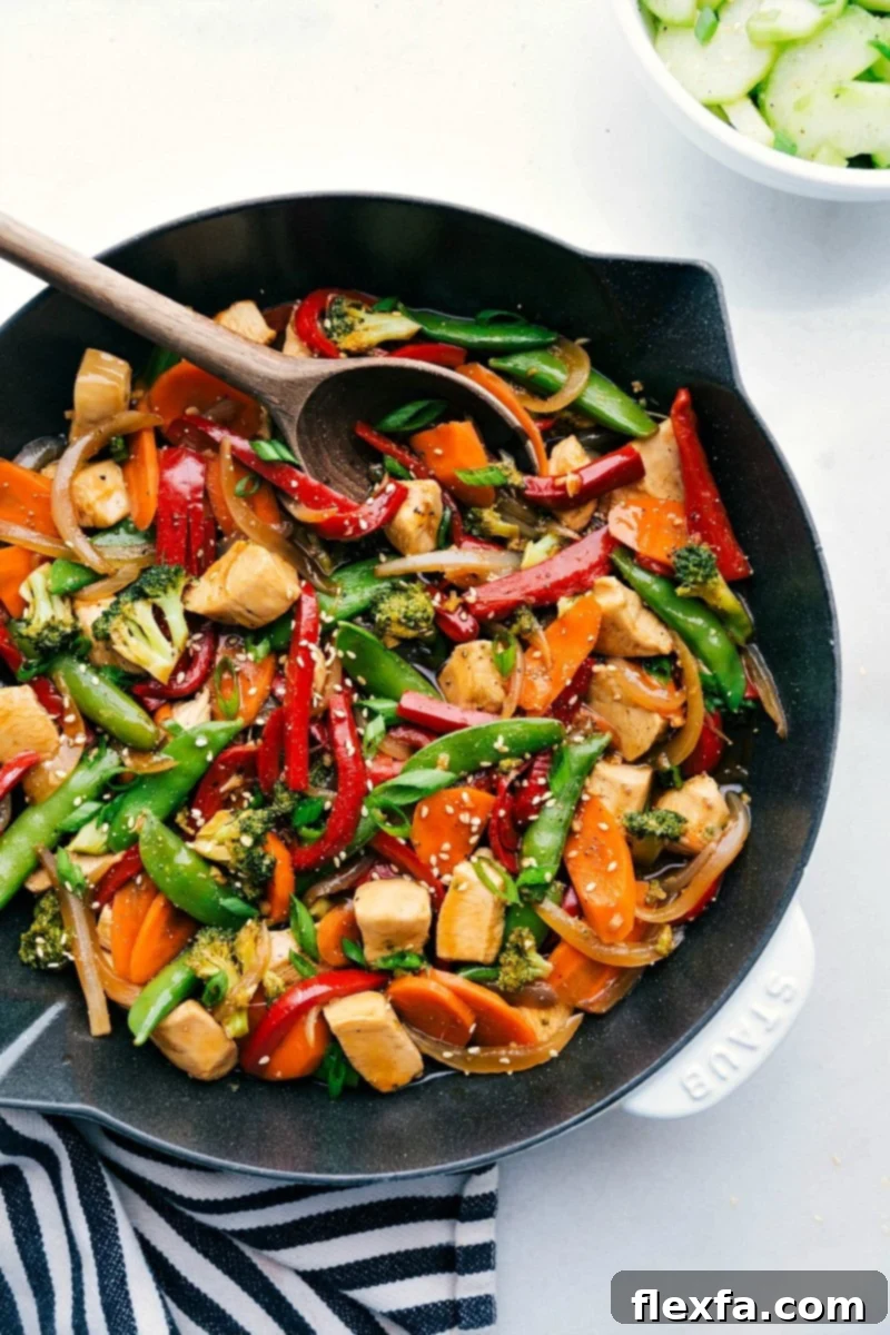 A vibrant chicken stir-fry in a skillet, brimming with fresh vegetables and flavorful chicken, ready for serving.