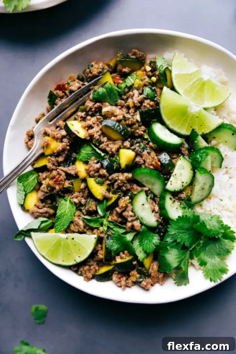 Flavorful Beef Larb served with rice and garnished with fresh lime and cilantro.