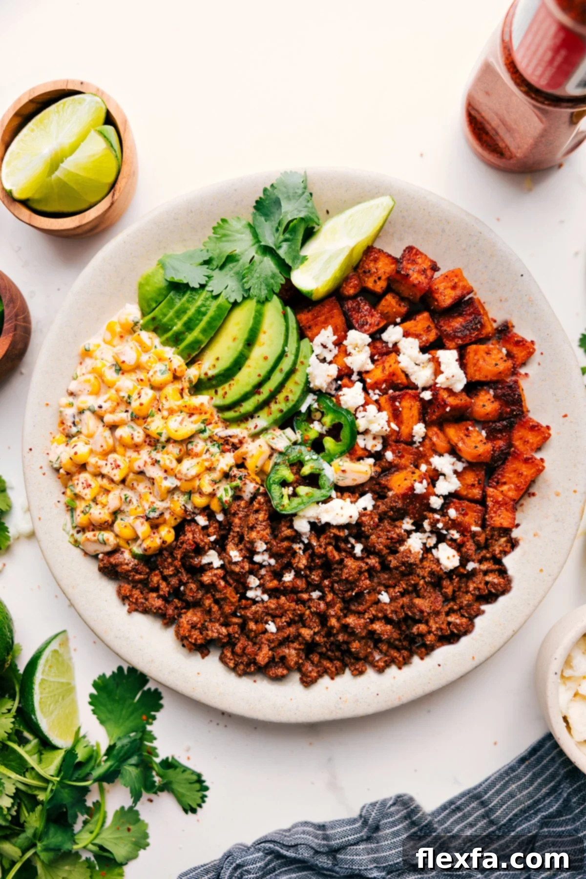 Healthy ground beef recipes: A delicious Street Corn Beef Bowl, featuring taco-seasoned ground beef, roasted sweet potatoes, creamy avocado, and Tajin-spiced street corn topping.