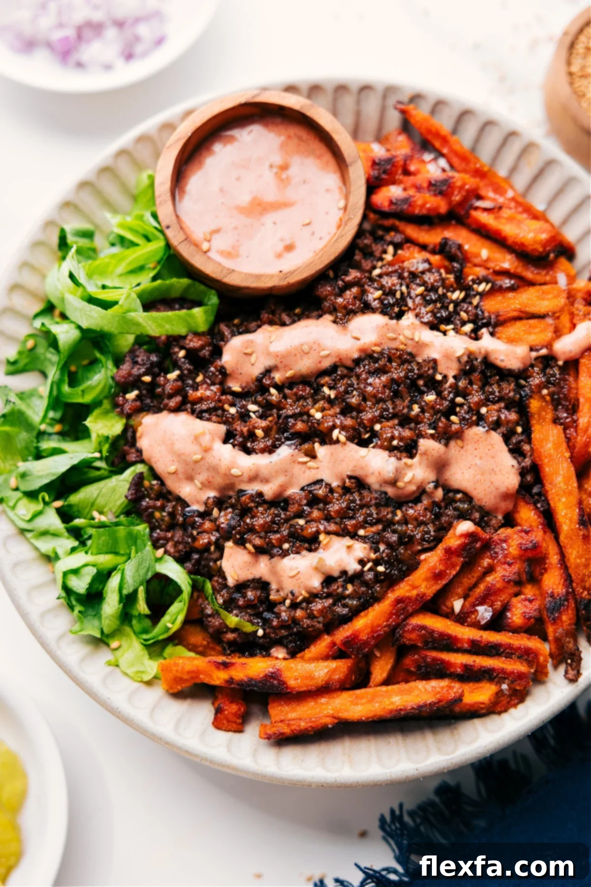 Satisfying low-carb burger bowls recipe with crispy sweet potato fries and a delicious burger sauce.