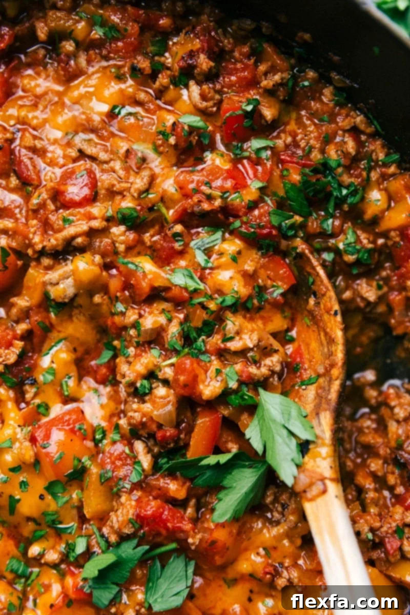 A skillet full of savory unstuffed peppers, brimming with seasoned meat, colorful vegetables, and fresh herbs.